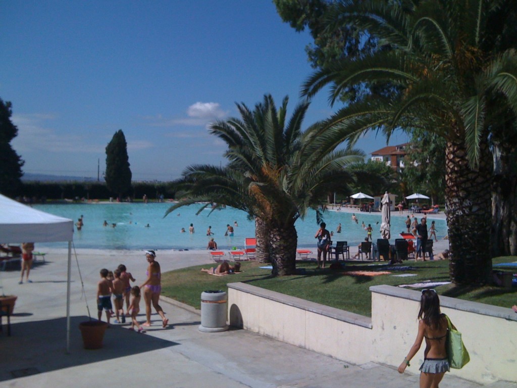 Acque Albule – Le Terme di Roma. Poolen "La Spiaggia" (stranden) där vattendjupet går från 0–160 cm i juli 2014. På vägen ned till vattnet syns också en del av en barngrupp från de olika sommarlägren. Denna aktivitet kostar mellan 75 € utan bespisning och 150 € inklusive bespisning.